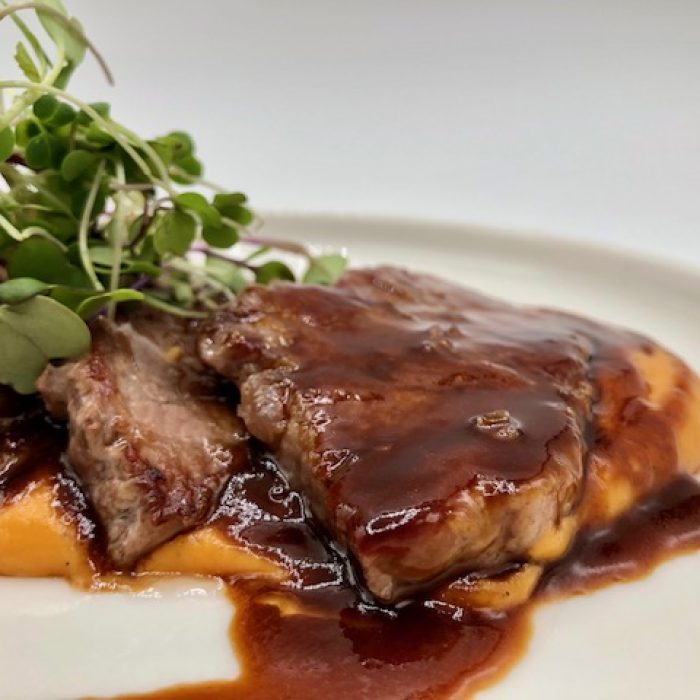 Presa de cerdo ibérico sobre cremoso de boniatos y jugo de jamón ibérico